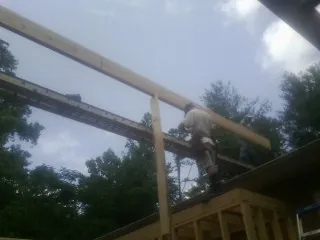 Carpenter setting a ridge beam over a new addition frame — Ice Dam Removal by Roofing Brothers in Niagara Falls