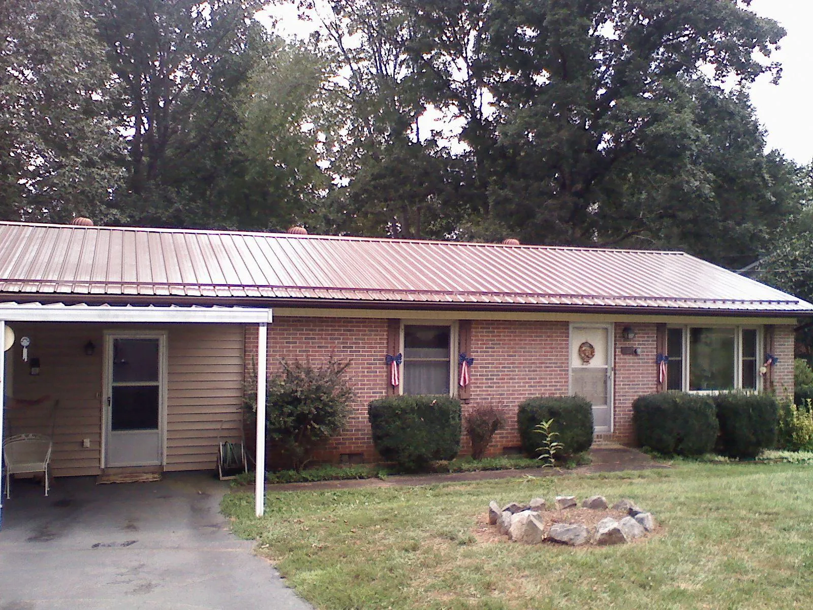 Bronze metal roof and carport on a brick ranch home — Roof Repair work by our crew in Niagara Falls